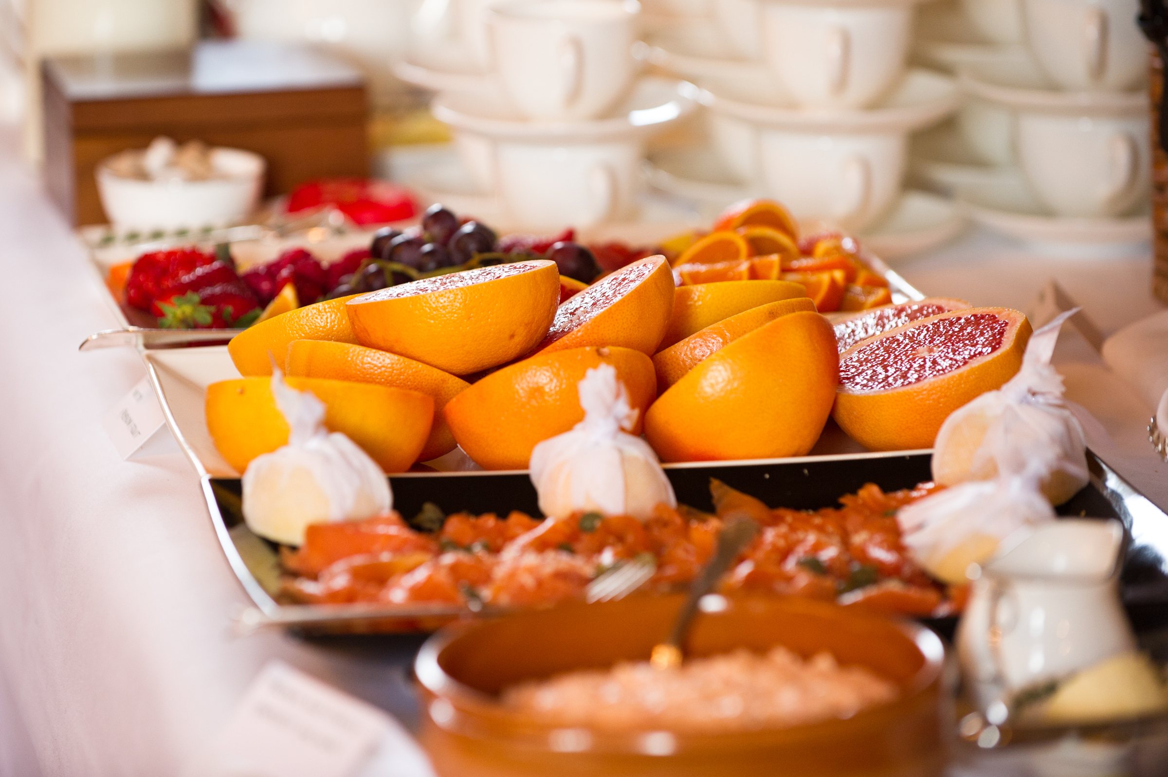 A breakfast table with oranges and fine china